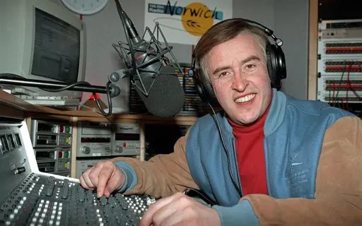 Alan Partridge sat in a radio booth at Radio Norwich